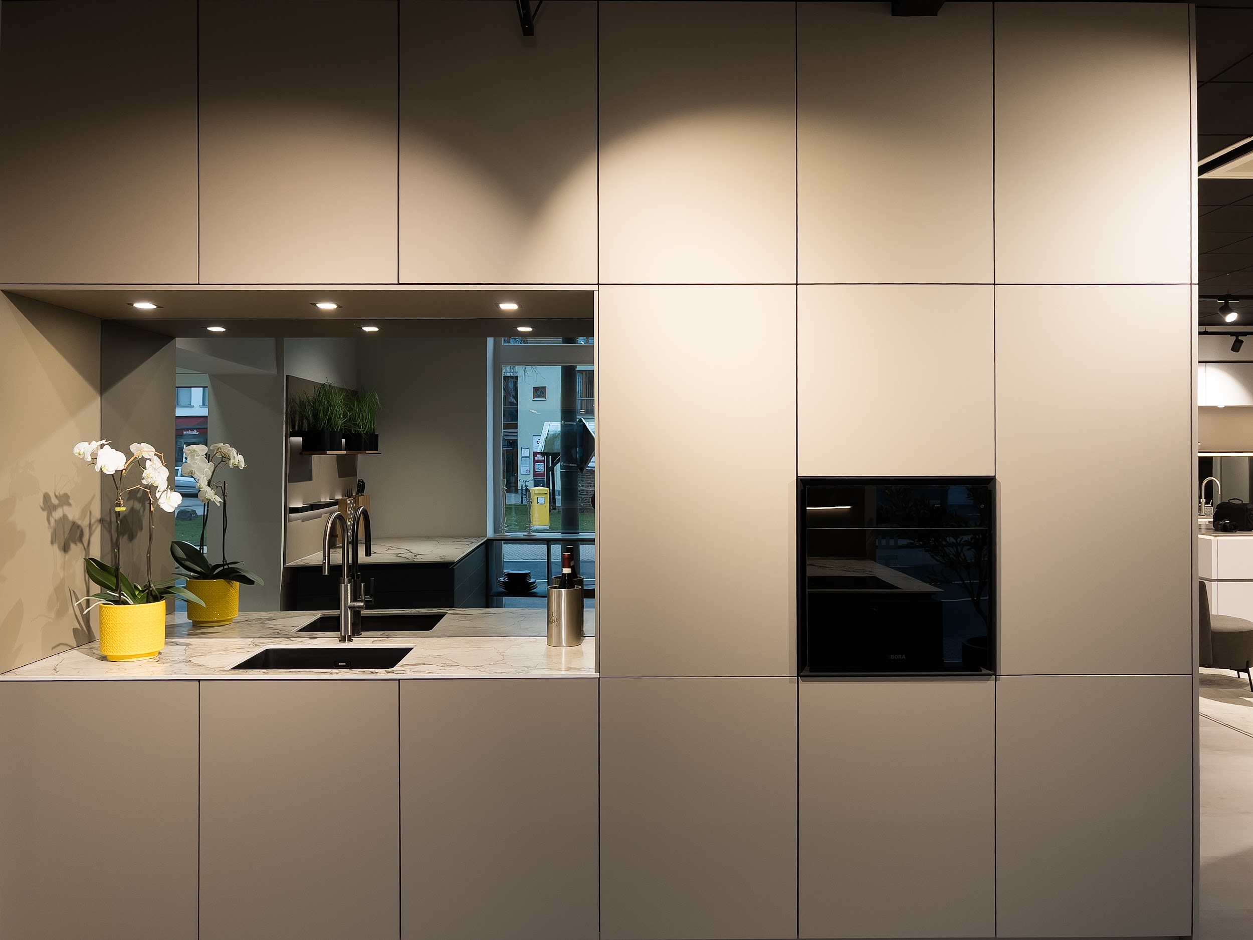 Integrierte Spülbecken-Nische mit indirekter Beleuchtung und Orchideen-Deko.