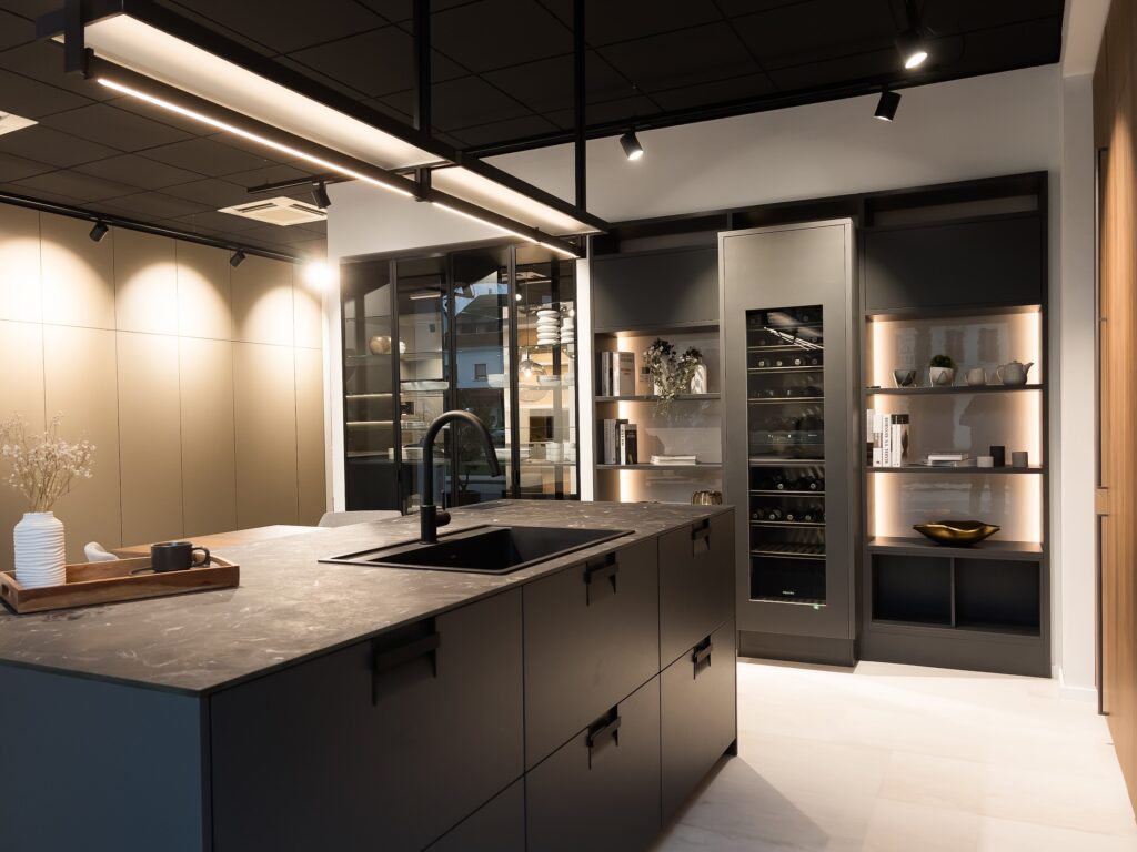 Schwarze matte Küche mit integriertem Weinklimaschrank und dunkler Spüle.
