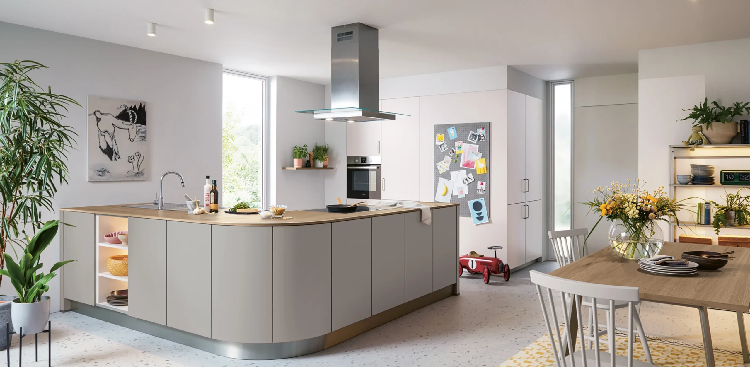 Moderne Schüller Familienküche mit großer Kochinsel in Beige und Grau, offener Wohnbereich mit Holzesstisch, perfekt für Familien in Bonn und Düsseldorf
